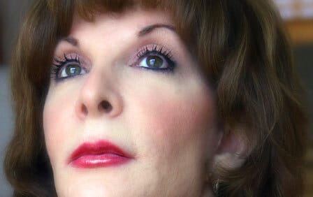 Headshot of poet Judith Harris looking up.