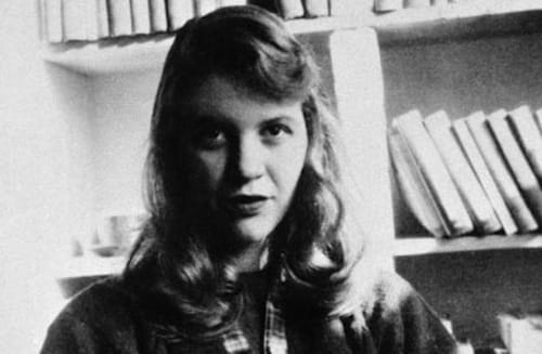 Image of Sylvia Plath in front of a bookshelf.