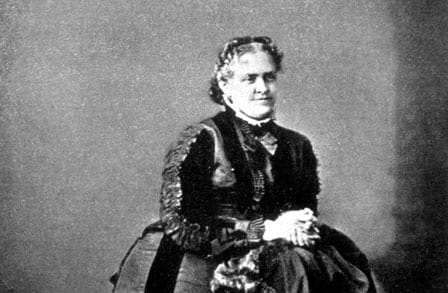 Black and white portrait of Helen Hunt Jackson sitting, hands clasped.