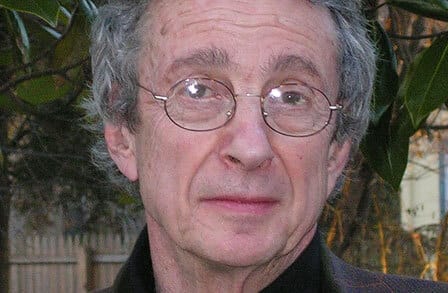 Headshot of poet C.K. Williams in front of plants.