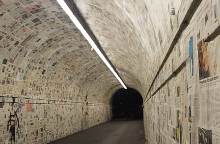 Image of a tunnel covered with newspaper pages.