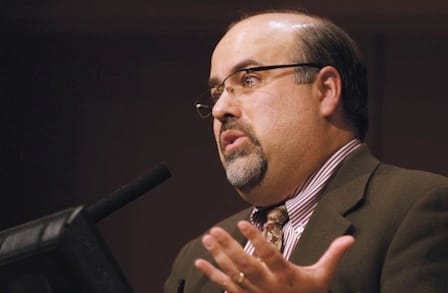 Headshot of poet Rafael Campo speaking at a podium.