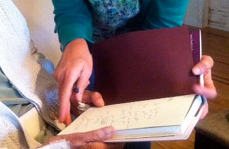 Photo of Carolyn Kizer and Annie Finch's hands on a book