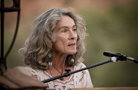 Headshot of poet Leslia Eullman at a microphone.