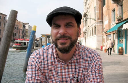 Photograph of poet David Caplan with a European town in the backdrop