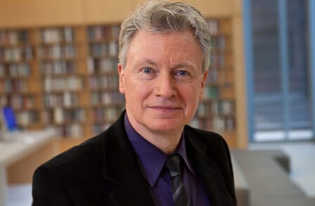 Headshot of Robert Polito in a suit and tie, in the Poetry Foundation library.