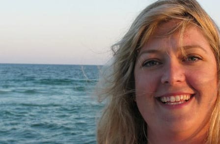 Poet Alison Pelegrin in front of the ocean.