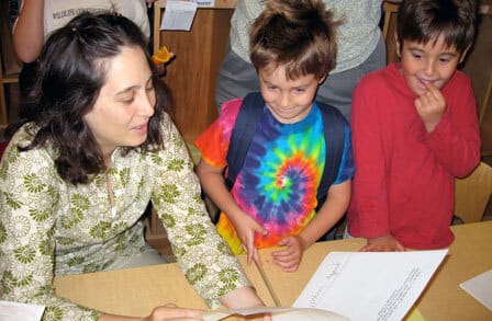 Poet Rachel Zucker reading to two elementary school students.