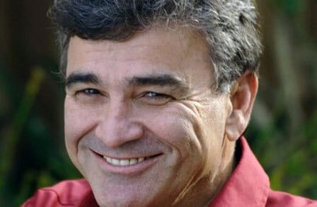 Headshot of writer Brod Bagert in a red button down shirt, smiling.
