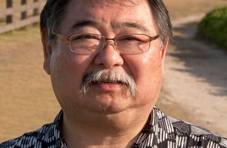 Headshot of writer Garrett Hongo in a gray patterned shirt.