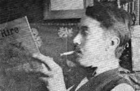 Black and white side portrait of Trumbull Stickney reading a periodical with a cigarette in his mouth.
