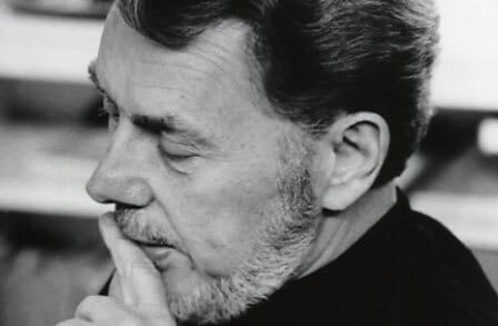 Black and white headshot of poet Theodore Weiss, with a finger on his mouth.