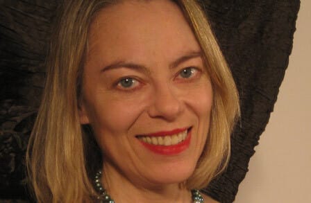 Headshot of poet Sharon Dolin, wearing red lipstick.