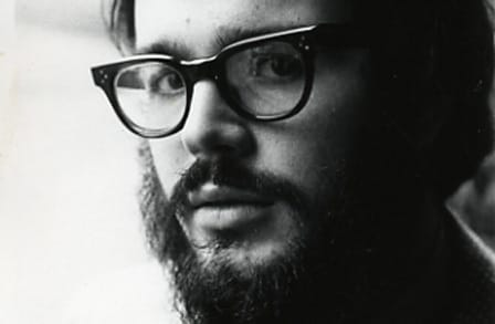 Black and white headshot of poet Greg Kuzma.
