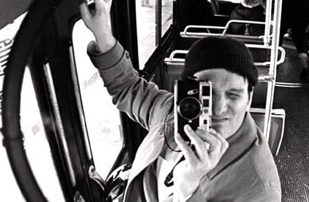Black and white headshot of writer Peter Spagnuolo with a camera covering over his face.