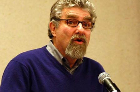 Headshot of Gregory Djanikan at a microphone.
