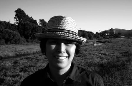 Black and white portrait photograph of writer Pamela Lu with a rural landscape behind them