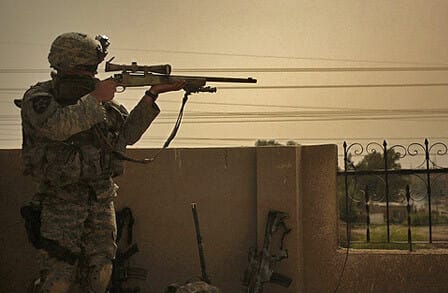 Photo of a US soldier in Iraq aiming a firearm