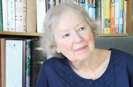 Headshot of writer Myra Sklarew in front of a bookshelf.