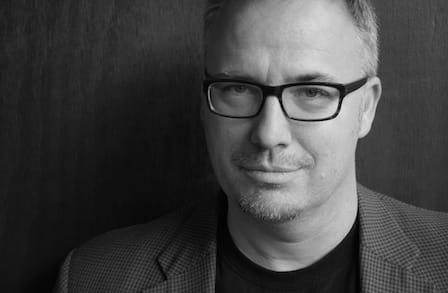 Black and white headshot of writer Daniel Nester in a tshirt and blazer.