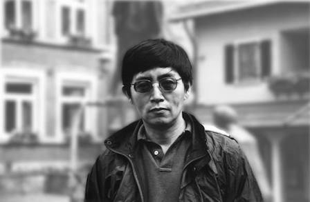 Black and white image of Bei Dao wearing sunglasses.