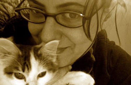 Orange-tinted photograph of the writer Judith Goldman hugging a cat