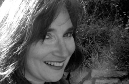 Black and white headshot of writer Lucia Perillo outdoors.