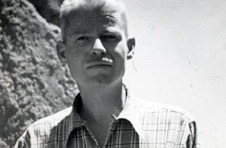 Black and white headshot of poet Norman Macleod in front of a mountain.