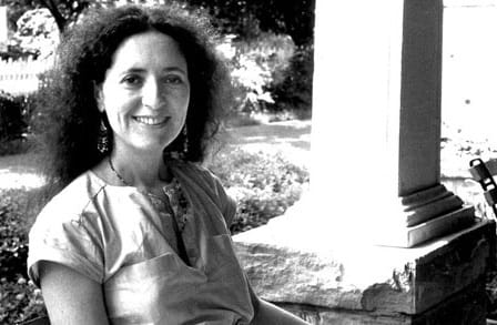 Andrea Hollander Budy outdoors by a pillar, black and white.