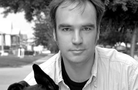 Black and white headshot of writer Richard Newman with a dog.