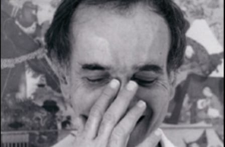 Black and white headshot of poet George Starbuck with his hand on his nose.