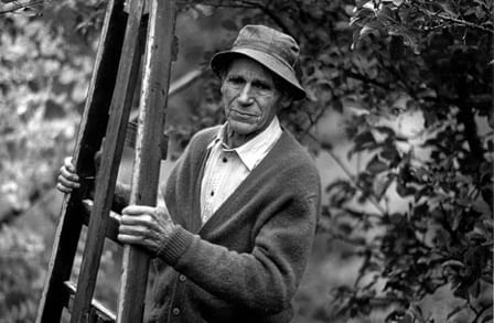 Black and white photograph of Norwegian poet Olav H. Hauge holding a easel