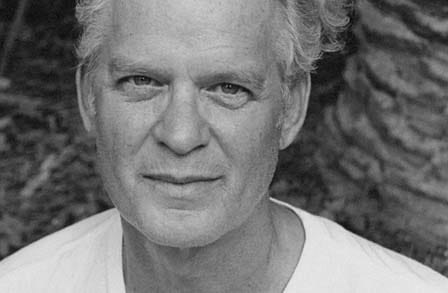 Black and white headshot of writer Charlie Smith outdoors.