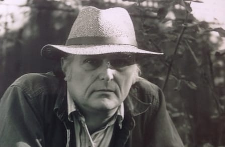 Image of Clark Coolidge, black and white, wearing a hat.