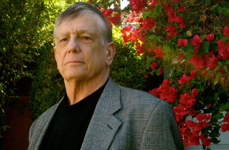 Headshot of poet Stephen Yenser in a garden.