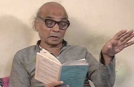 Marathi poet Vinda Karandikar reading from a book.