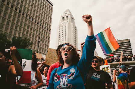 Image of a protestor raising a fist and participating in a parade.