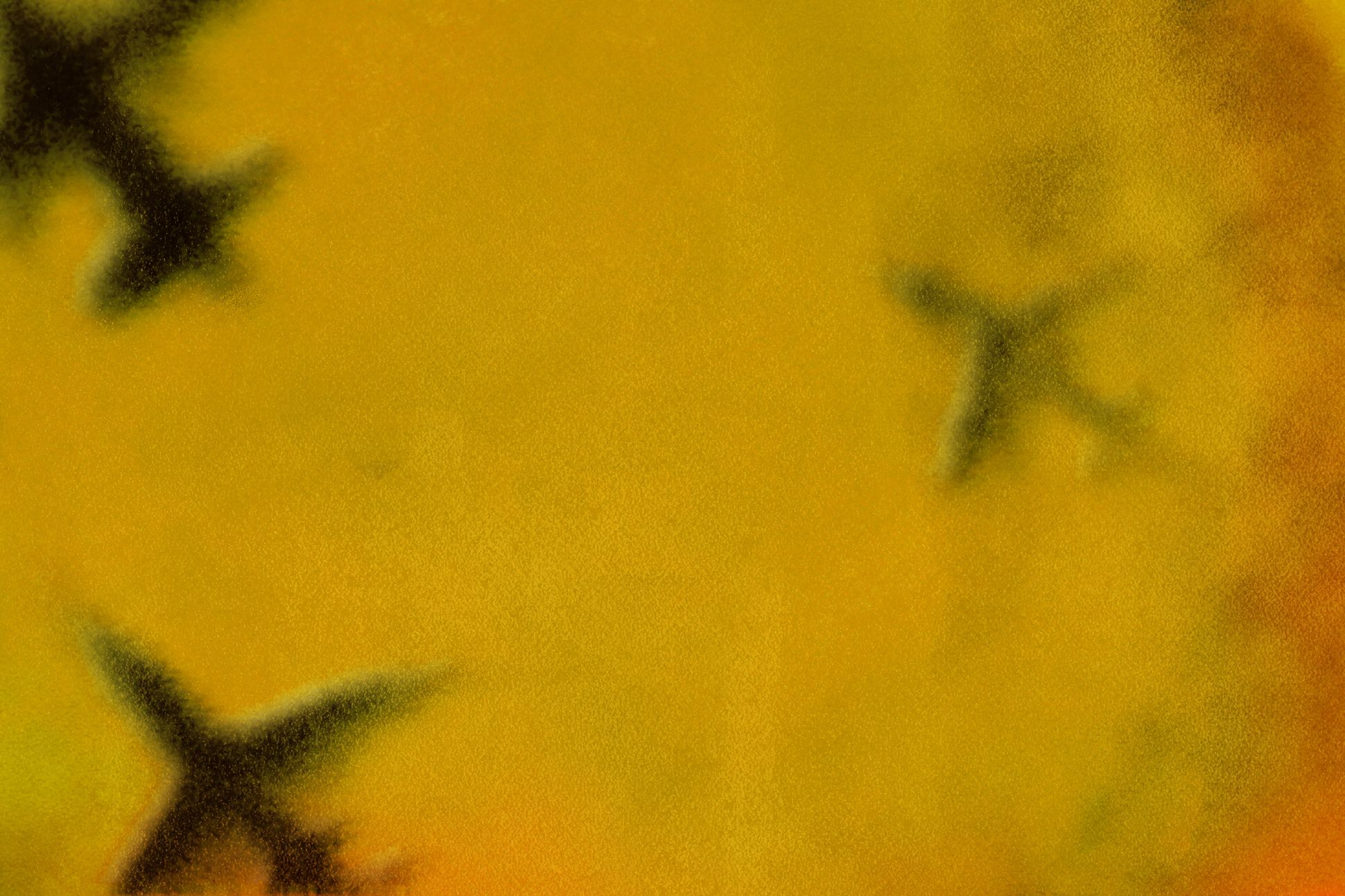 Three airplanes flying inside a yellow haze.