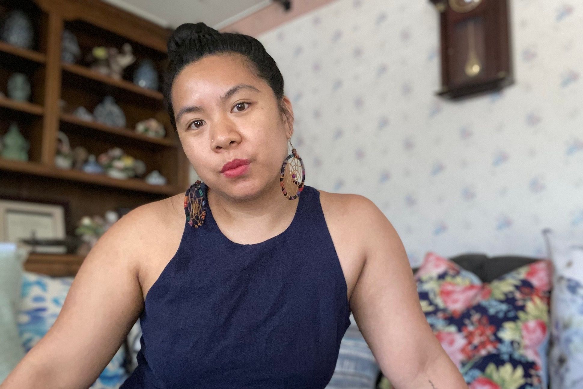 Asian woman with floral cushions in a living room