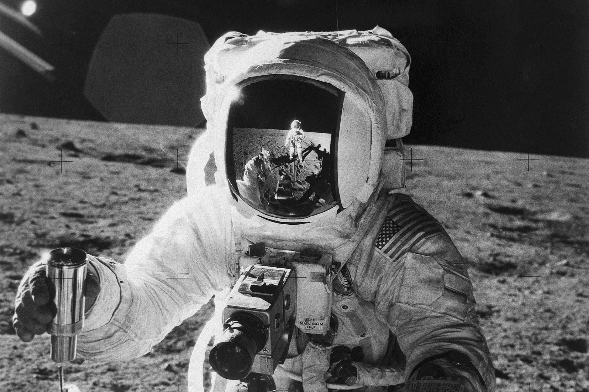 Black-and-white photo of Apollo 12 astronaut Alan Bean's face mask reflecting Commander Charles Conrad.