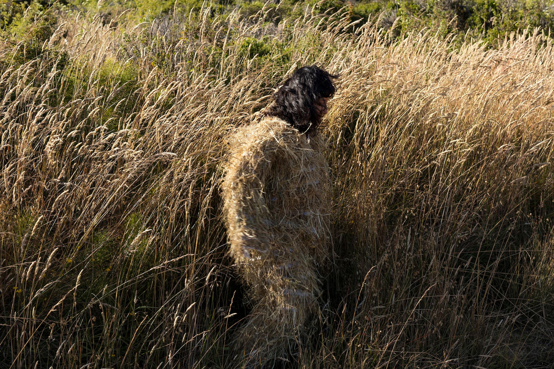 Image a woman camouflaged in a wheat field.
