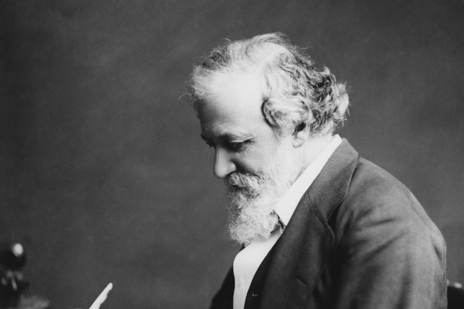 English poet Robert Browning (1812 - 1889) writng at a desk, circa 1880.