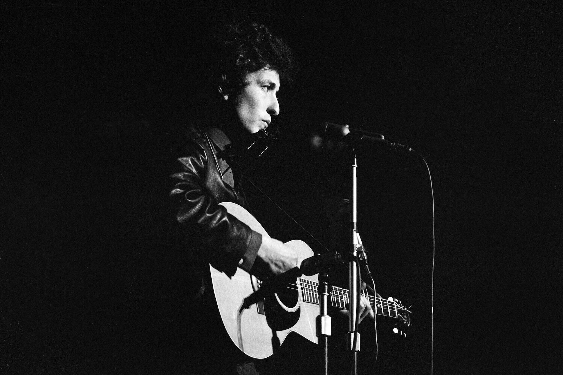 Black and white image of Bob Dylan performing in 1965.