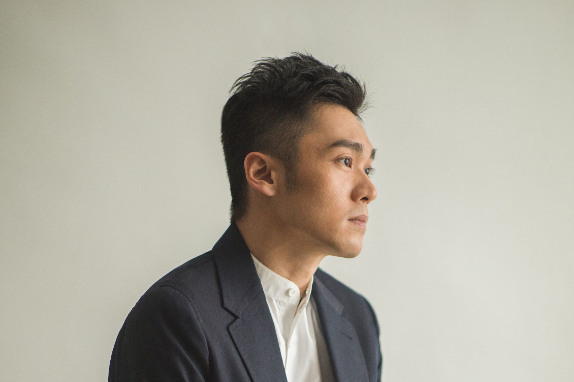 Asian man in navy blue suit with a white background