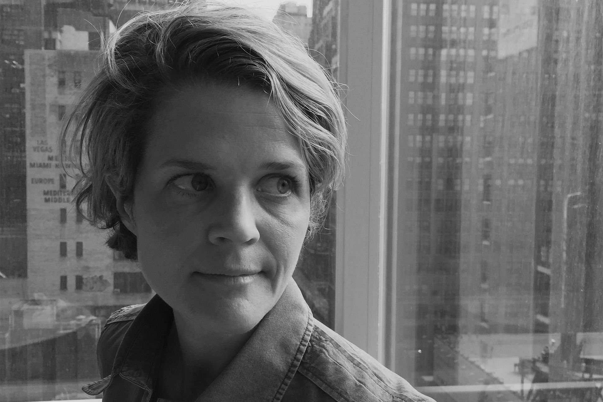 Black-and-white portrait of Eliza Griswold standing against part of a city skyline.