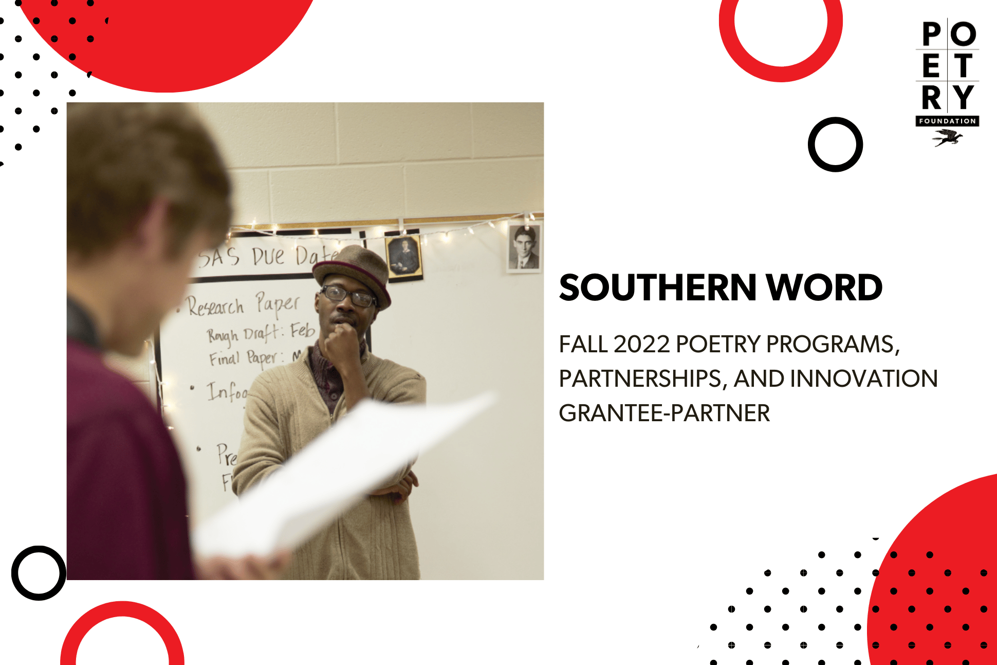 Adult man standing in front of a whiteboard with text on it while a student holds a piece of paper in front of himself and reads from it.