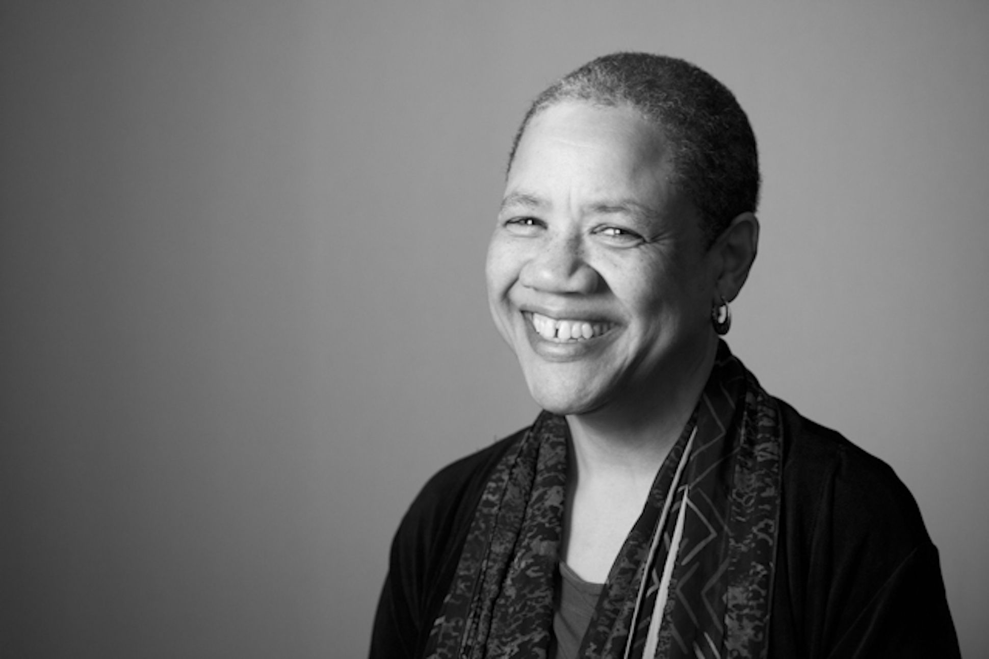 Black and white portrait of a black woman in a scarf smiling
