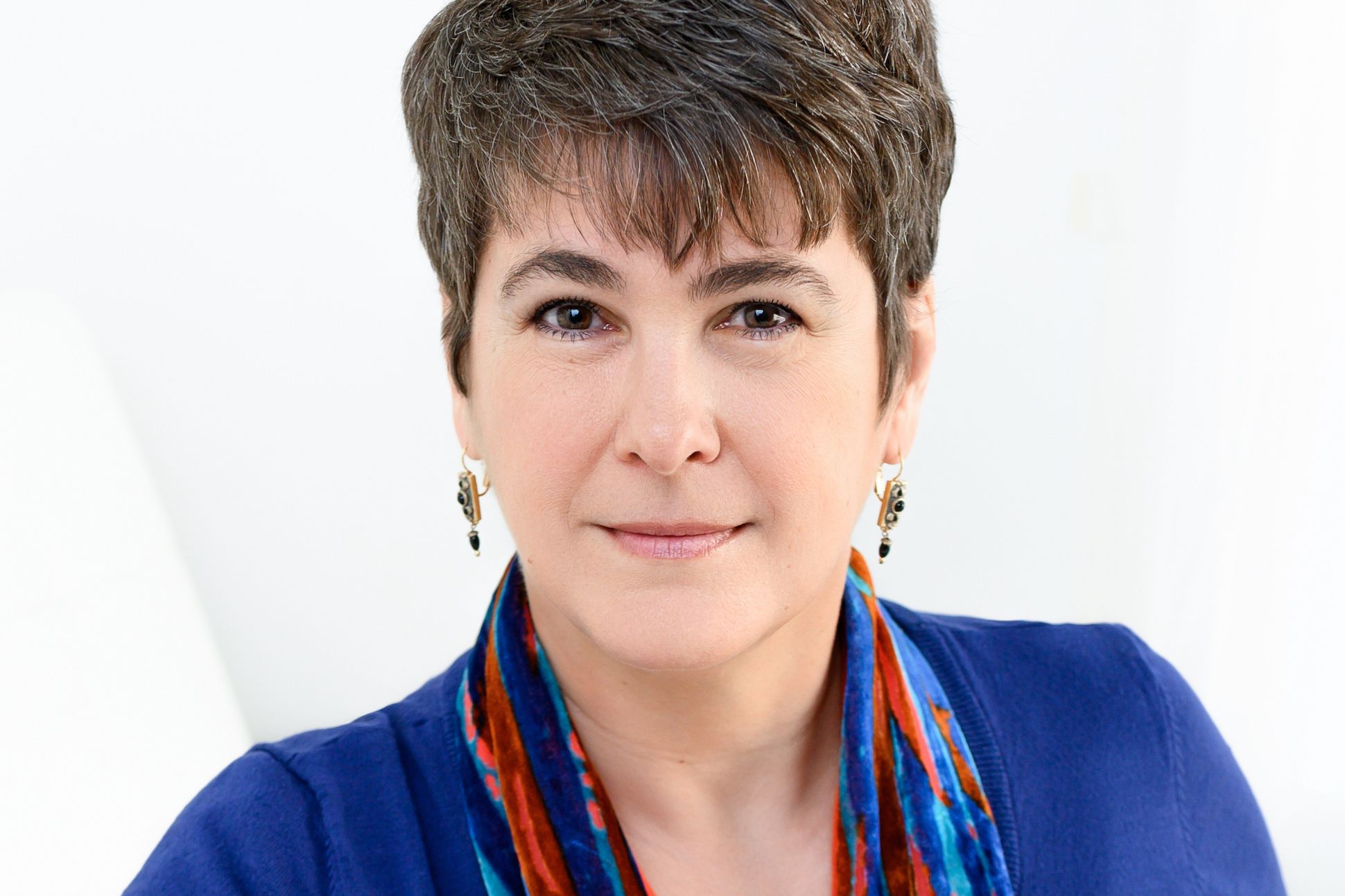 A woman with pixie hair wearing a blue blouse