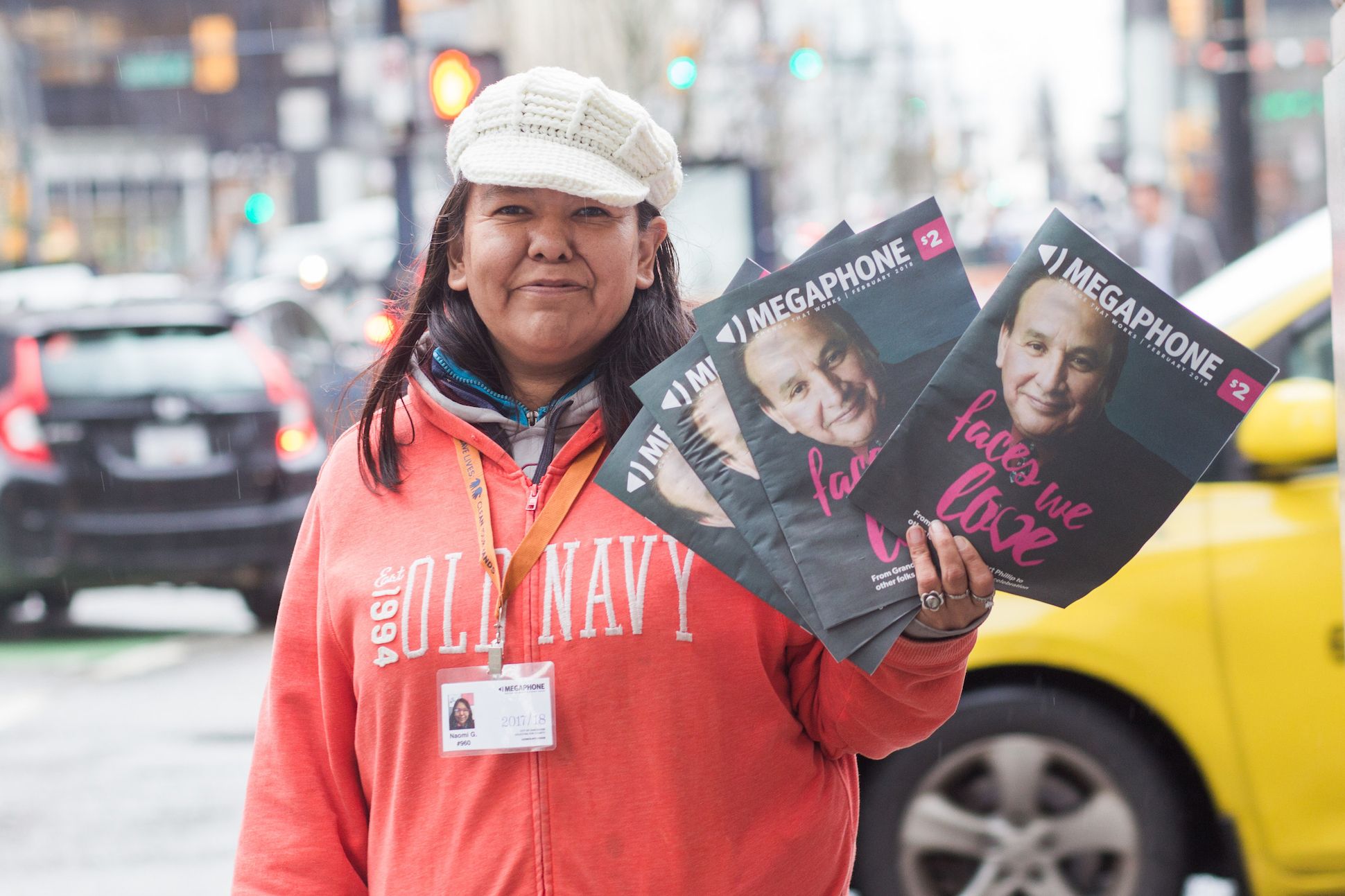 Image of a Megaphone vendor holding issues of the street paper in Vancouver, Canada.