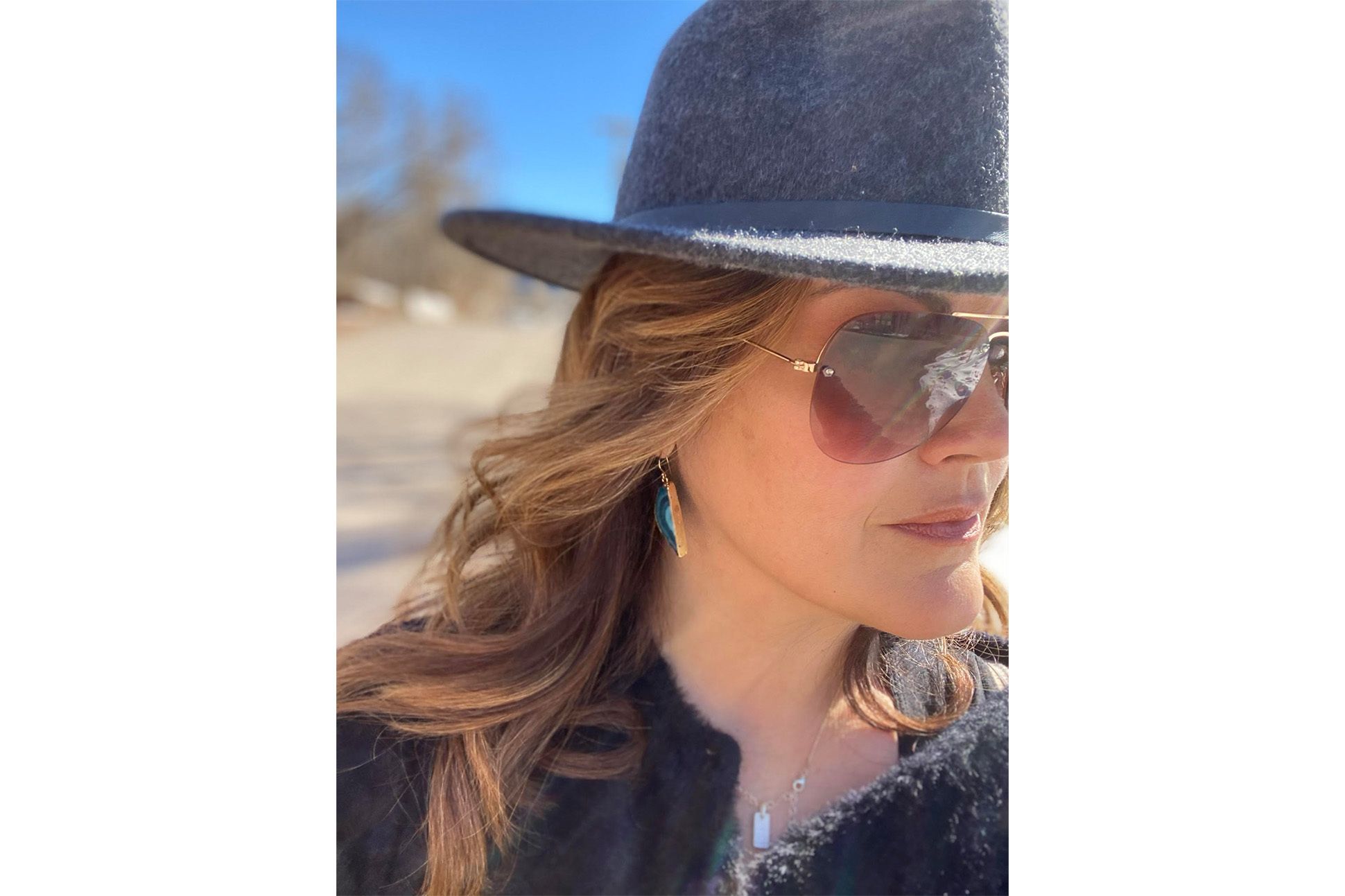 Headshot of poet Kierstin Bridger wearing a cowboy hat and a pair of sunglasses